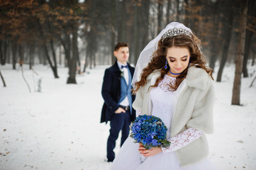  Young stylish wedding couple at forest on winter day. Loving new