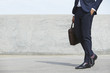 Businessman walking with case, side view