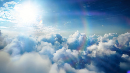 Wall Mural - Flying over the timelapse clouds with the afternoon sun. Flight through moving cloudscape with beautiful lens flare. Traveling by air. Perfect for cinema, background