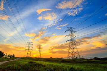 A high voltage of transmission tower in the morning sunrise with the beauty of a blue sky