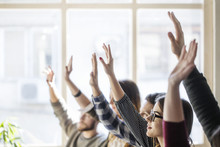Students Raising Hands During Lesson In Classroom