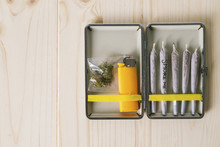 Overhead View Of Marijuana Joints With Cigarette Lighter In Container On Table