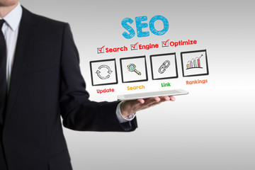 Wall Mural - SEO concept, young man holding a tablet computer