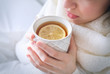 © Africa Studio - Young ill woman drinking hot tea with lemon at home, closeup