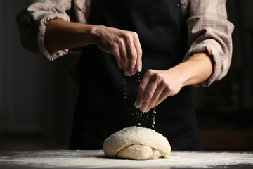 Sticker - Man sprinkling flour over fresh dough on kitchen table