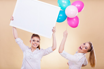 Two girls with blank board and balloons