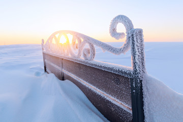 The back forged snow-covered benches.