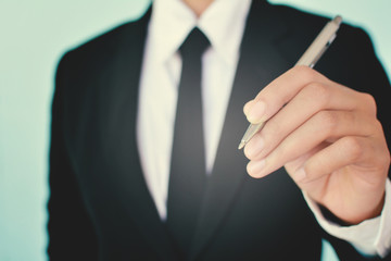 Wall Mural - Portrait of Businesswomen holding a pen on blue background 