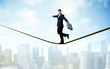 © ra2 studio - Salesman walking on rope above the city