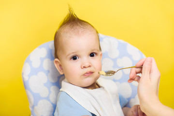 mother feeding her baby breast porridge day