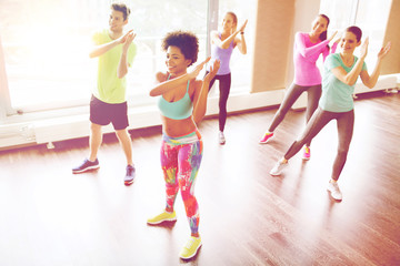 Canvas Print - group of smiling people dancing in gym or studio