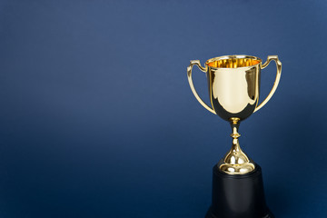 Wall Mural - gold winner cup on blue background