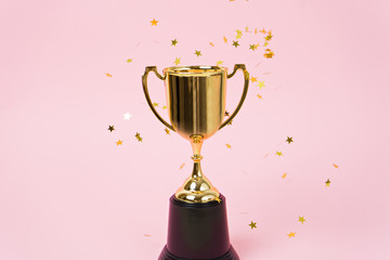 gold winner cup on pink background