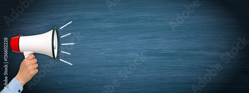 Cuadros en Lienzo Megaphone with hand on blue horizontal chalkboard background with copy space for