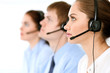 © rogerphoto - Call center operators. Focus at brunette business woman in headset