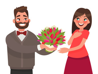 Man gives a woman a bouquet of flowers. Congratulations on a hol