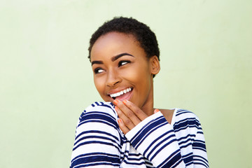 Wall Mural - smiling young woman with hand over mouth