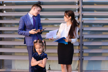 In foreground stands little girl and angry, in background beauti