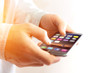 © Production Perig - Hand holding black smartphone with operating system screen