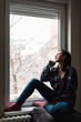 © djrandco - Young woman by the window thinking about life