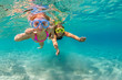 © Tropical studio - Happy family - mother with baby girl dive underwater with fun in sea pool. Healthy lifestyle, active parent, people water sport outdoor adventure, swimming lessons on beach summer holidays with child