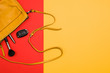 Woman's accessories flat lay on colorful background. Top view. Red and yellow pastel colors with copy space around products. Horizontal image or photograph.