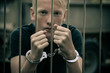 Handcuffed teenage boy behind bars