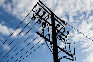 Electric pole connect to the high voltage electric wires with  blue sky background.