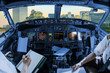 Airplane cockpit flying on New York City with World Trade Center and Twin Towers, Manhattan, United States, with pilots arms and blank white papers for copy space.