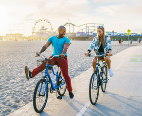 couple having fun riding bikes together at santa monica california