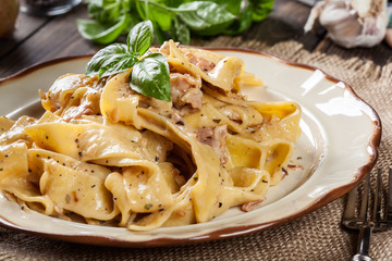 Wall Mural - Pappardelle pasta with prosciutto and cheese sauce on a plate