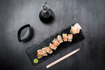 Wall Mural - Tasty and delicious traditional japanese sushi roll with seafood and fish on black wooden background