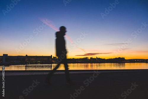 Fotografia Silhouette of a man walking in Oslo at sunset