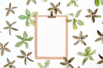 Clipboard and floral pattern with green leaves. Flat lay, top view. Flower background.