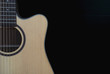 © pairhandmade - Closeup of cutaway acoustic guitar over black background