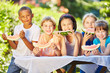 Kinder essen zusammen Melonen