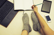 © grufnar - female legs wearing surrounded by multiple communication devices writing in a notebook