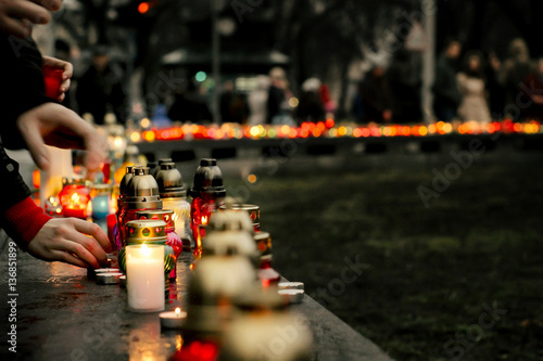 Fotografía crowd of people lighting candles in city center, mourning victim