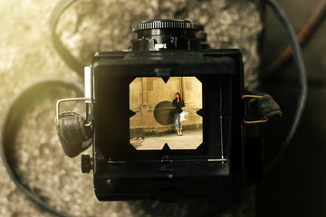 Wall Mural - stylish happy woman in viewfinder of  analog film camera on back