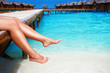 © Ivan Kurmyshov - Women's legs at wooden pier of tropical island resort