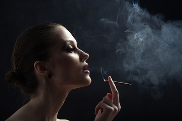 Wall Mural - luxury woman smoking cigarette on black background