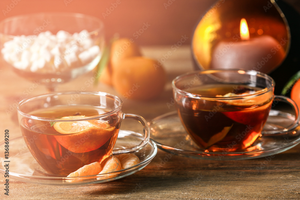 Two cups of tangerine tea on wooden background