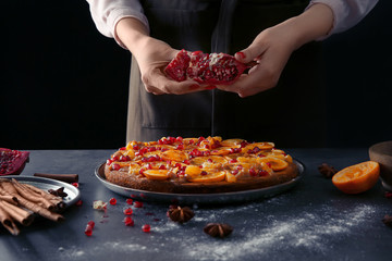 Canvas Print - Woman chef decorating delicious tangerine pie on kitchen table