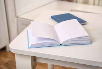 Sticker - Open book on white wooden table