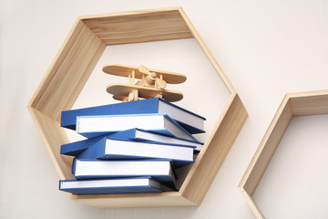 Sticker - Stack of books on wooden shelf against light wall