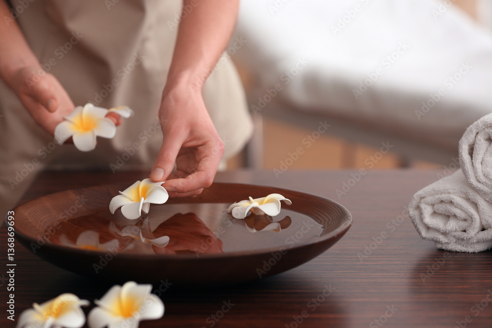 Spa concept. Female hands with bowl and exotic flowers