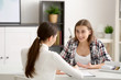Young female psychologist working with teenager girl in office