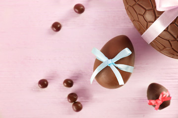 Sticker - Chocolate Easter eggs with color ribbon bows on wooden background