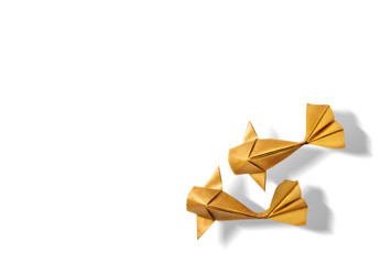 handmade paper craft gold color origami koi carp fish on white background with empty space.