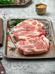 Canvas Print - Raw steaks on iron tray on light surface